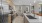 Large well lit kitchen with wood floors and stainless steel appliances.