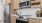 Large well lit kitchen with wood floors and stainless steel appliances.